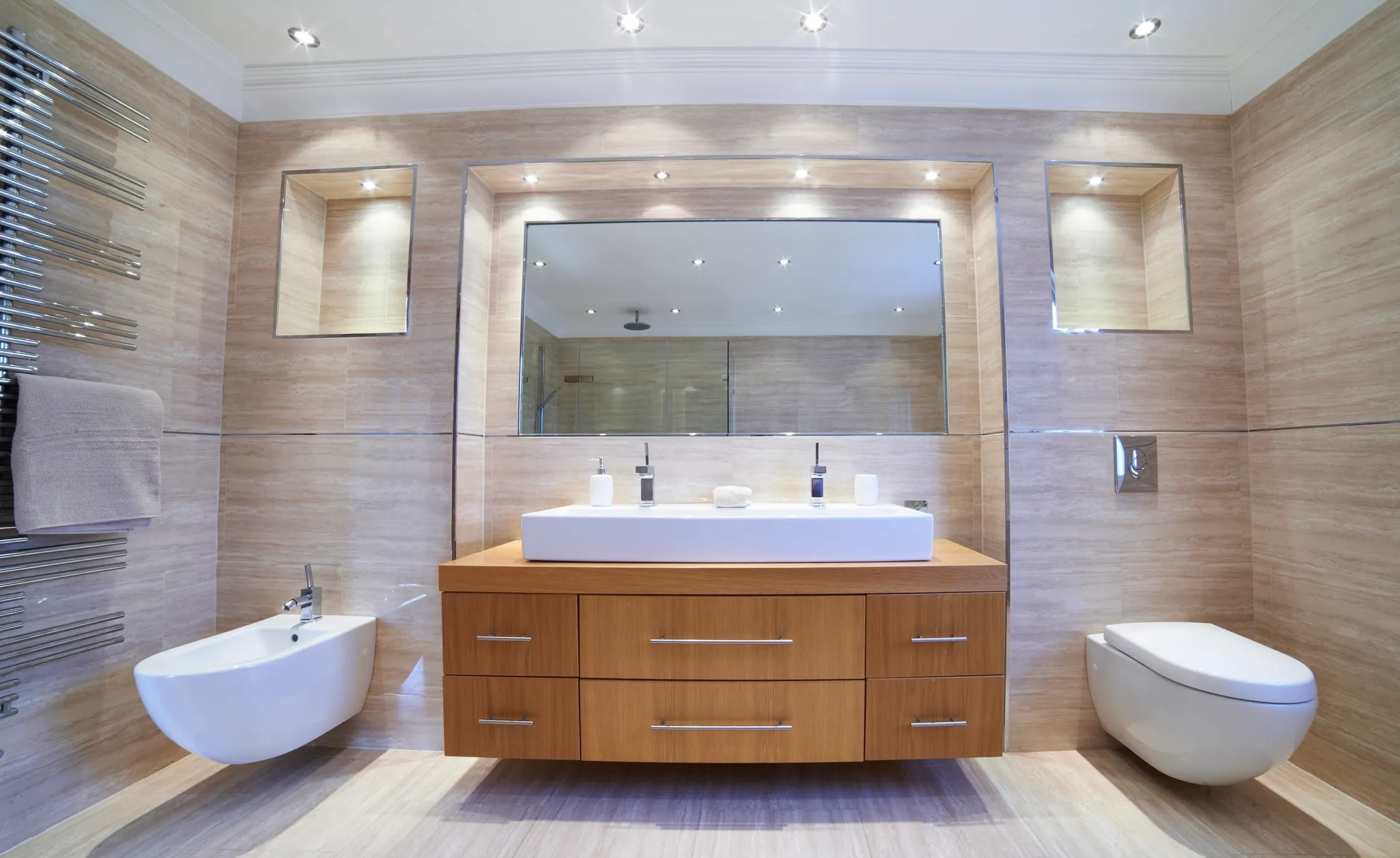 wide sink with cove lighting on both toilets